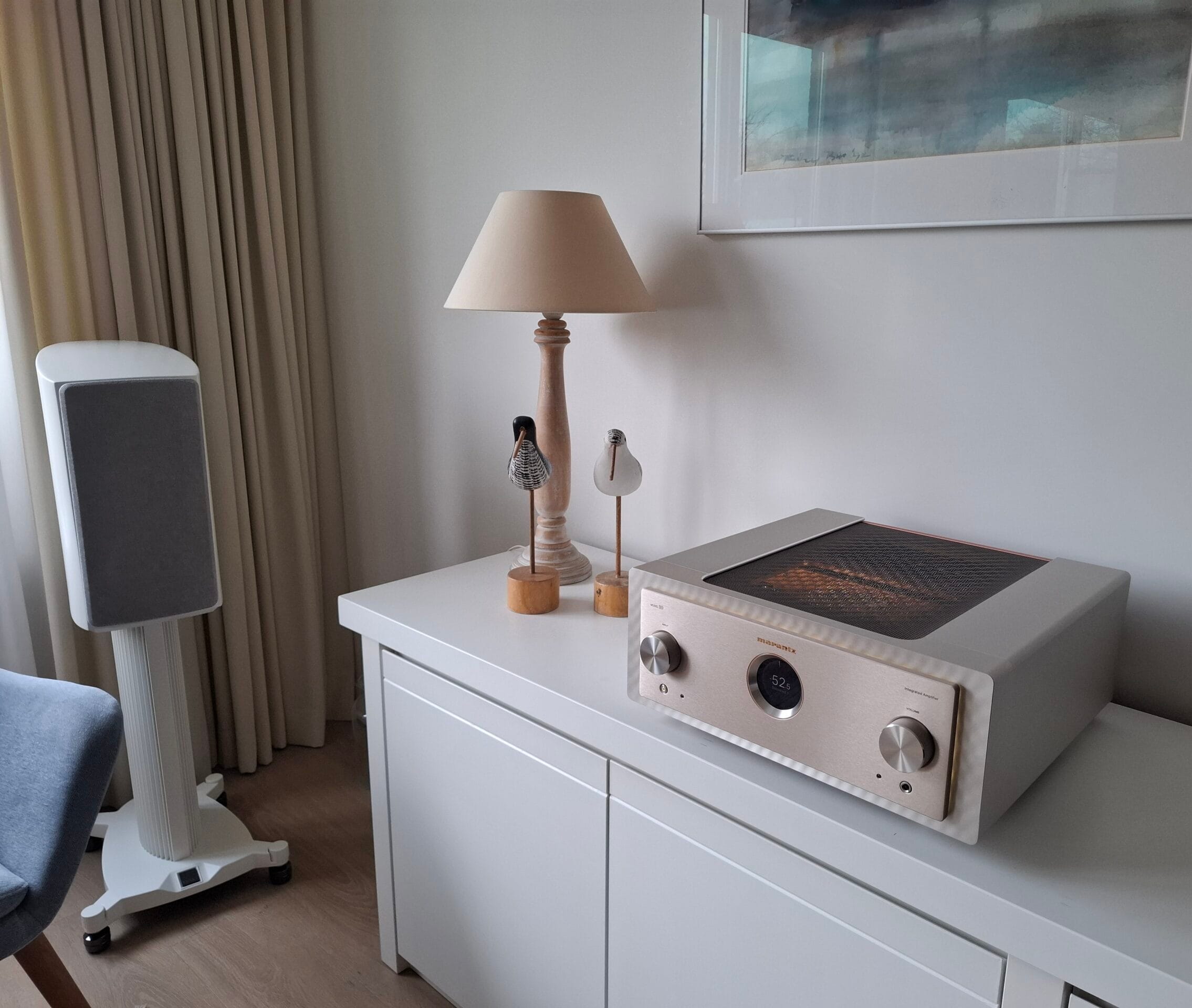 een marantz model 10 versterker in het champagne op een kast met een lamp ernaast witte pianlak dali epikore 3 speakers op een witte bijpassende poot